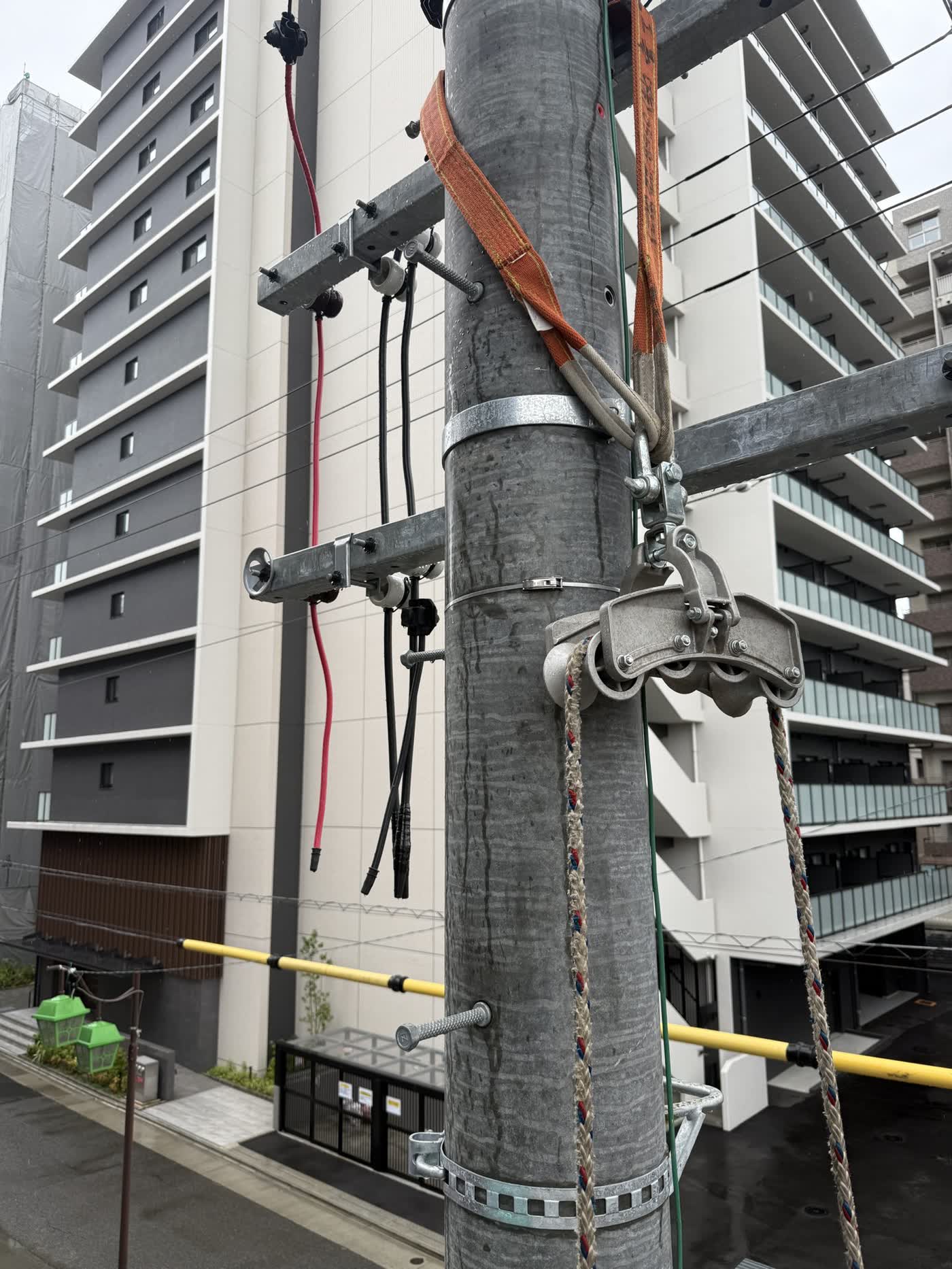 電柱に取り付けた滑車とロープ。マンションへの幹線引き込み