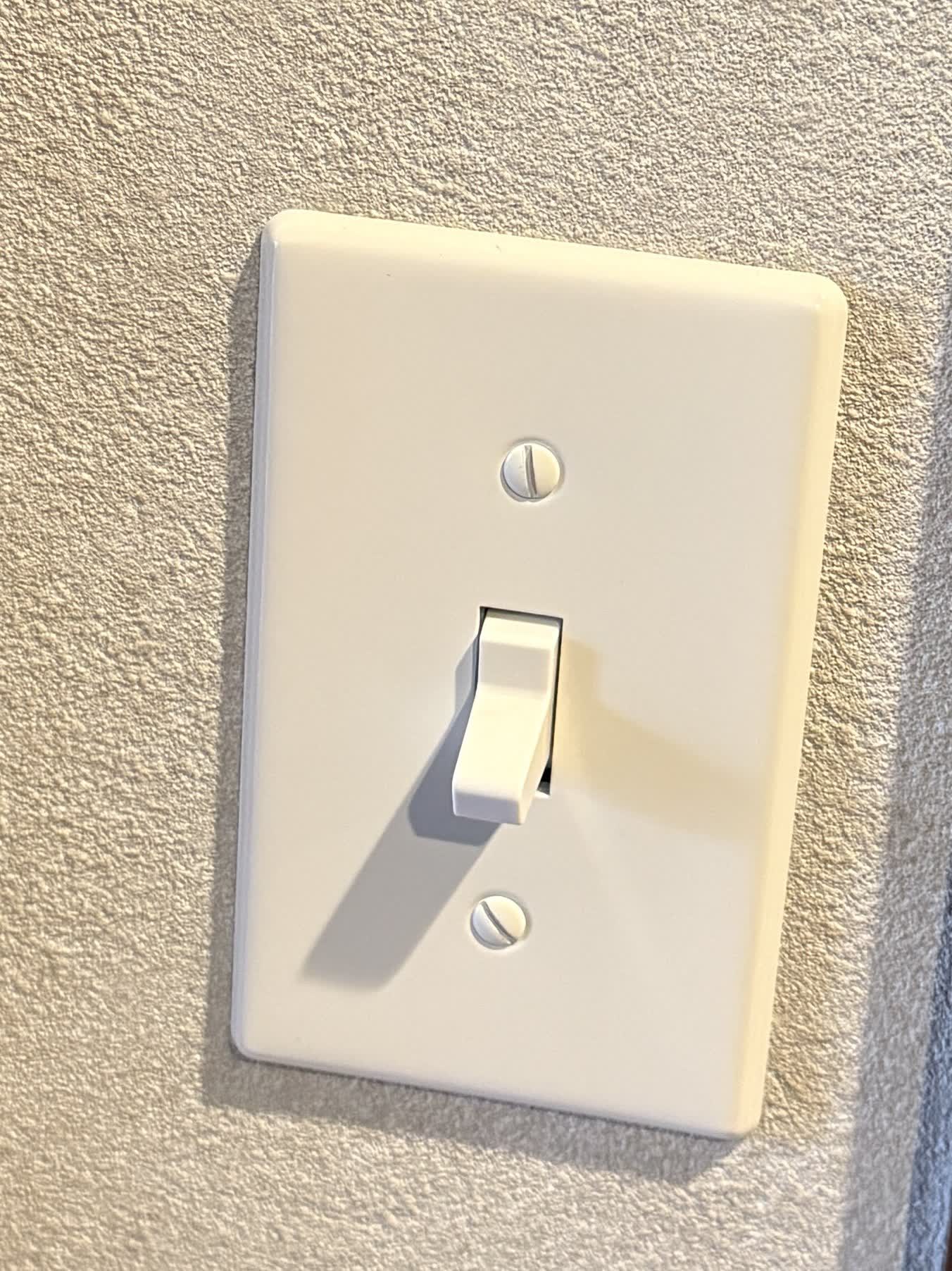 壁に取り付けたレバー式のスイッチ